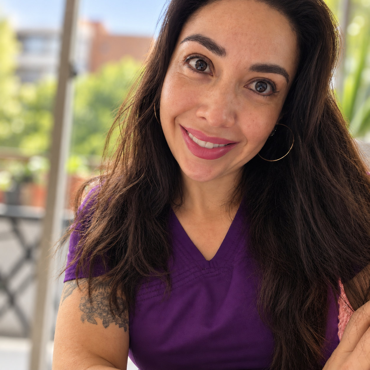 Vale Pezo sonriendo, con top blanco y un fondo de plantas